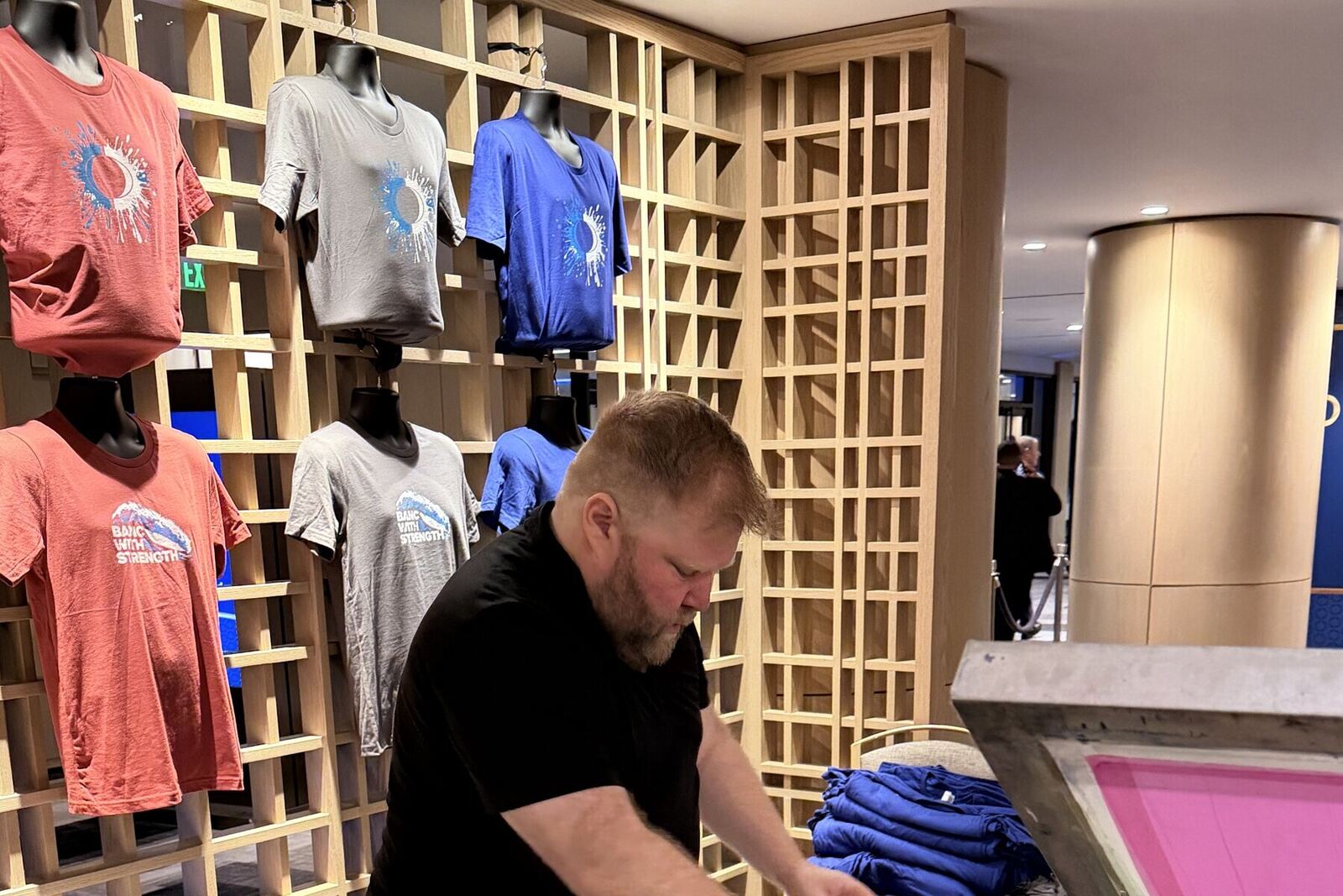 Rack of printed shirts on display at a Merch Troop on-site swag activation