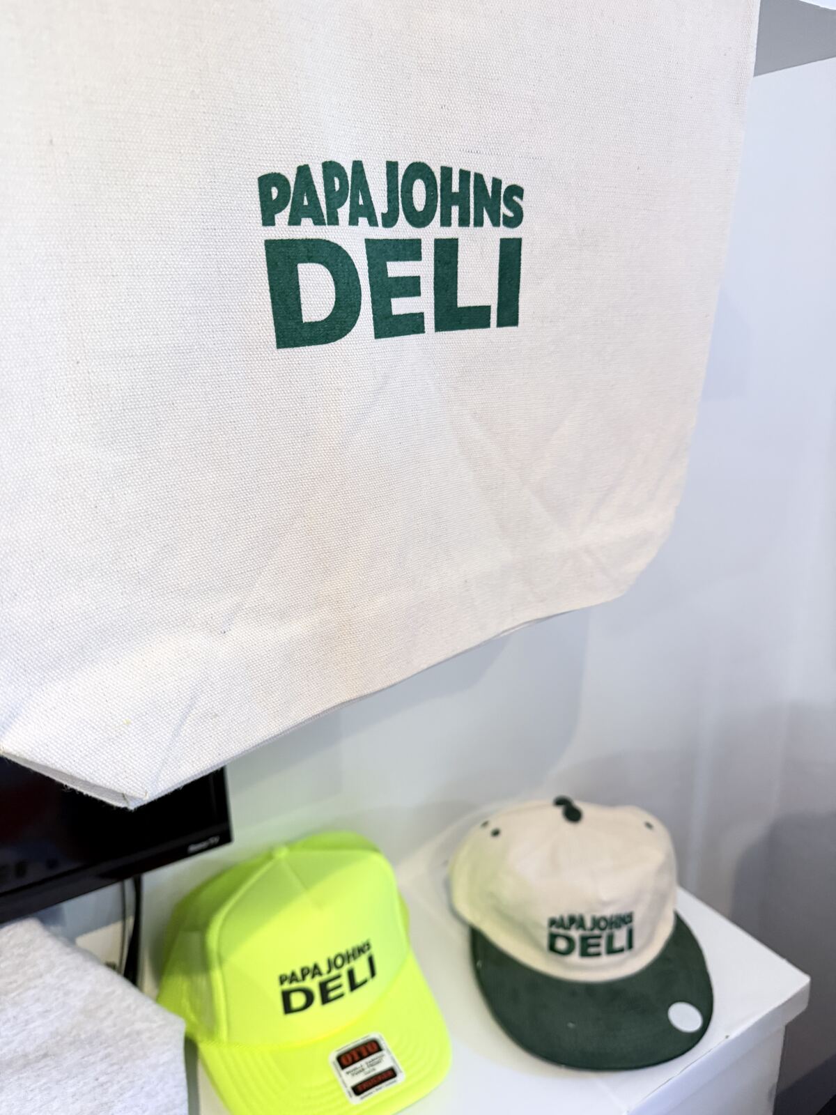 Close-up of branded promotional caps and apparel with screen-printed logos on a display surface